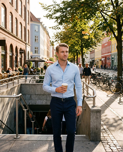 Mann i lyseblå Heldagsskjorte med kaffe på vei opp fra T-banen